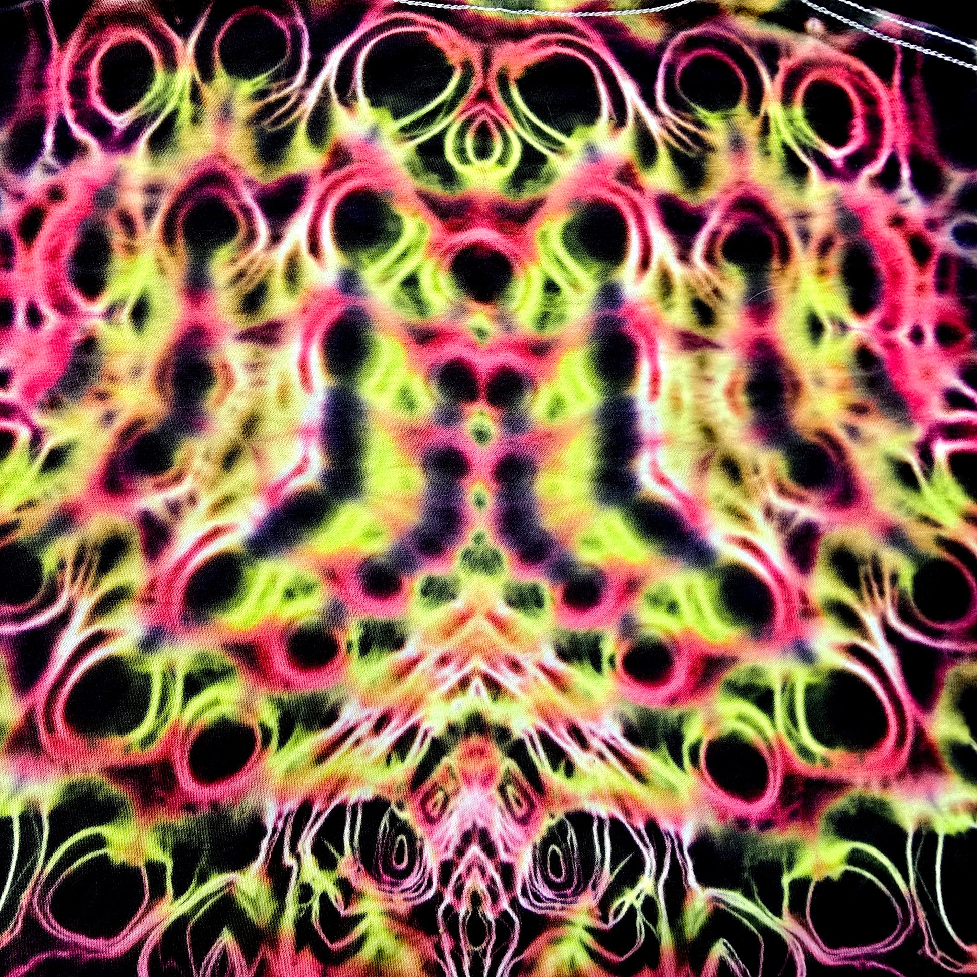 Colorful tie-dye pattern with black circles on a multicolored background