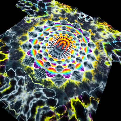 A tie-dye t-shirt featuring a highly detailed, symmetrical mandala pattern with a rainbow spectrum of colors on a black base.