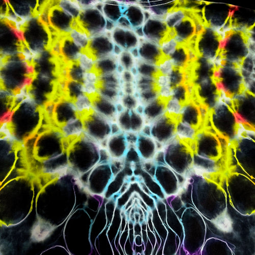 A close-up of a tie-dye fabric pattern with a symmetrical, kaleidoscopic design featuring black, neon yellow, light blue, red, and purple colors.