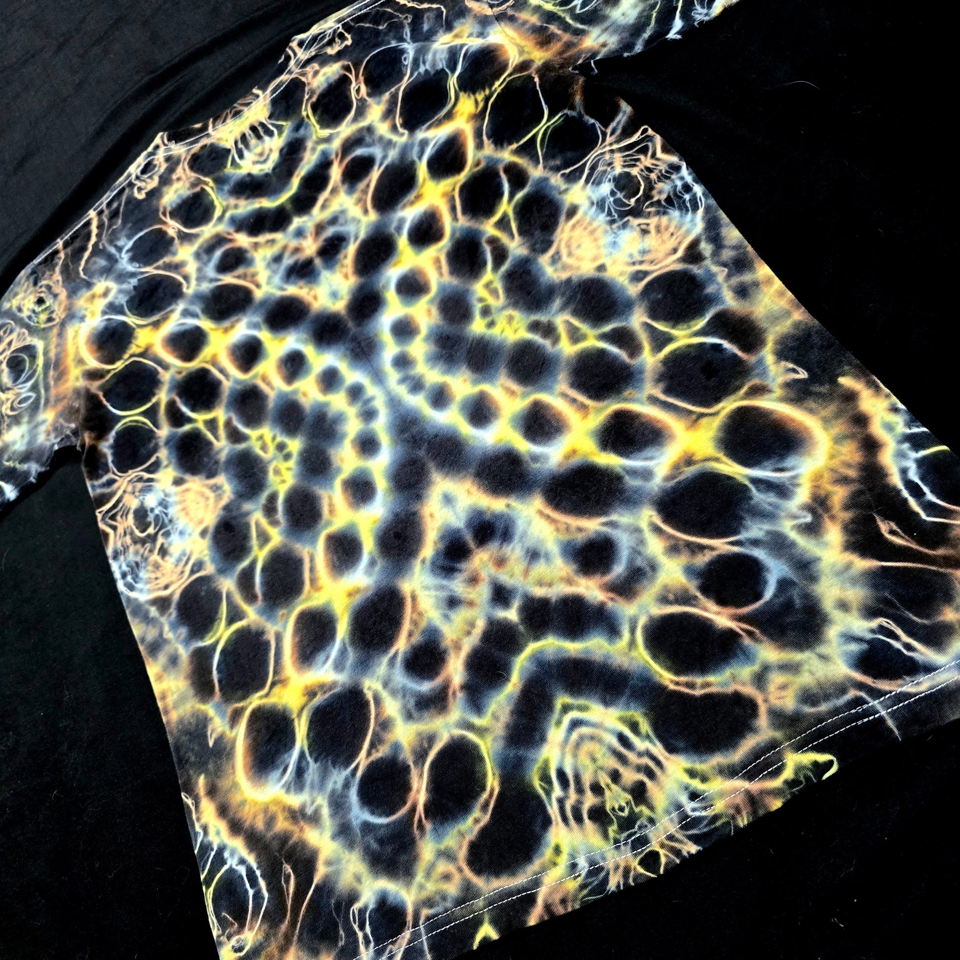 Hand-dyed tie-dye shirt with organic lightning-like amber and gold pattern on black cotton