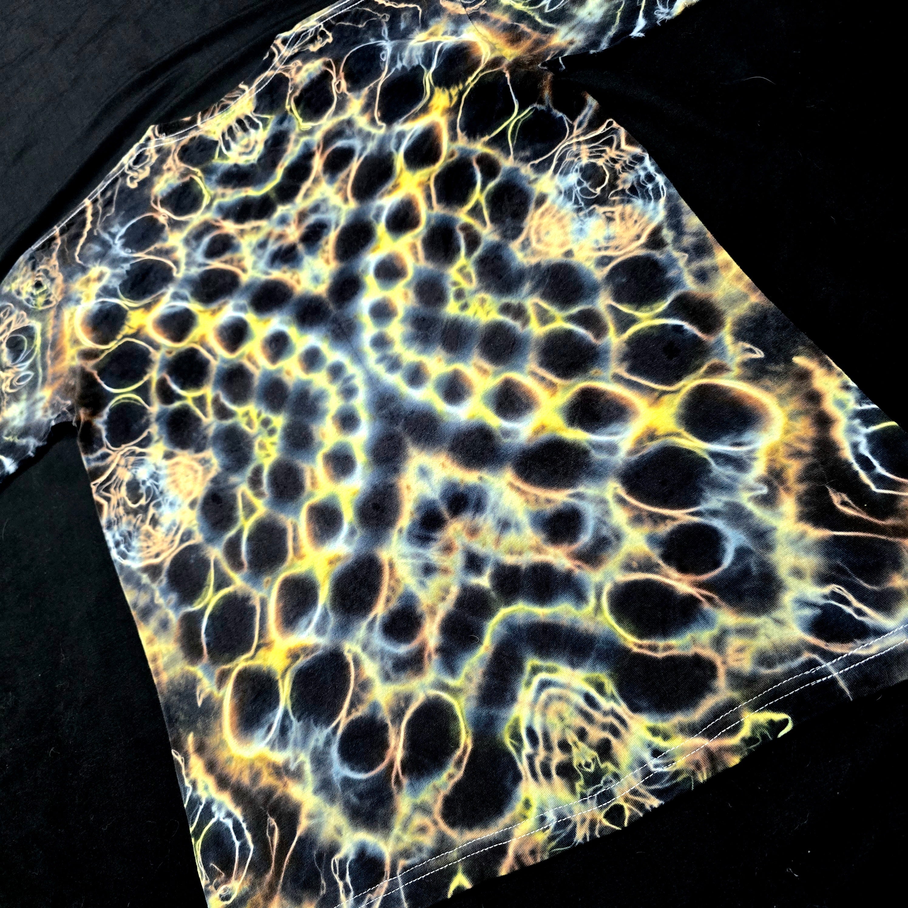 Hand-dyed tie-dye shirt with organic lightning-like amber and gold pattern on black cotton