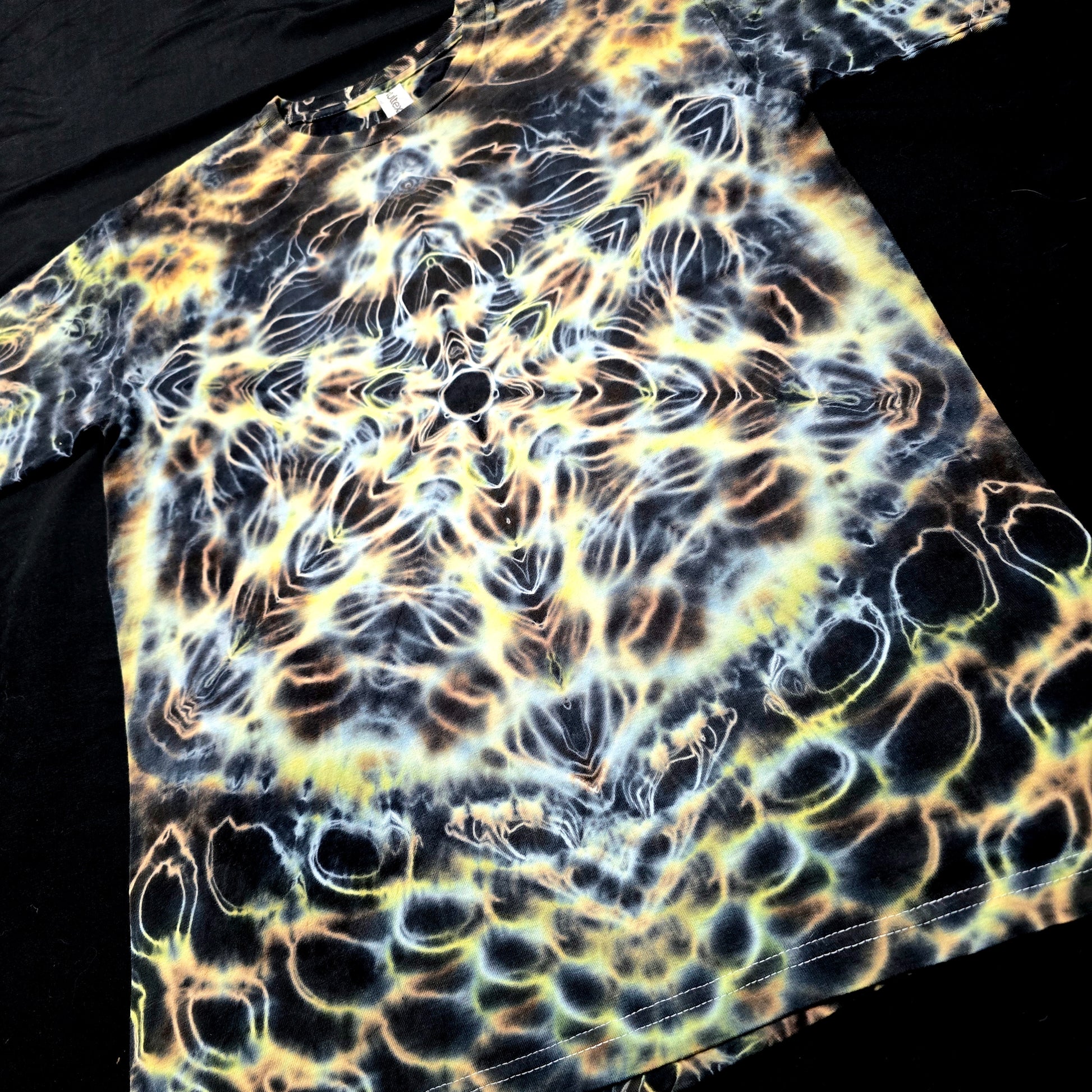 Close-up of Amber Flux tie-dye design showing molten amber tones and mirrored symmetry