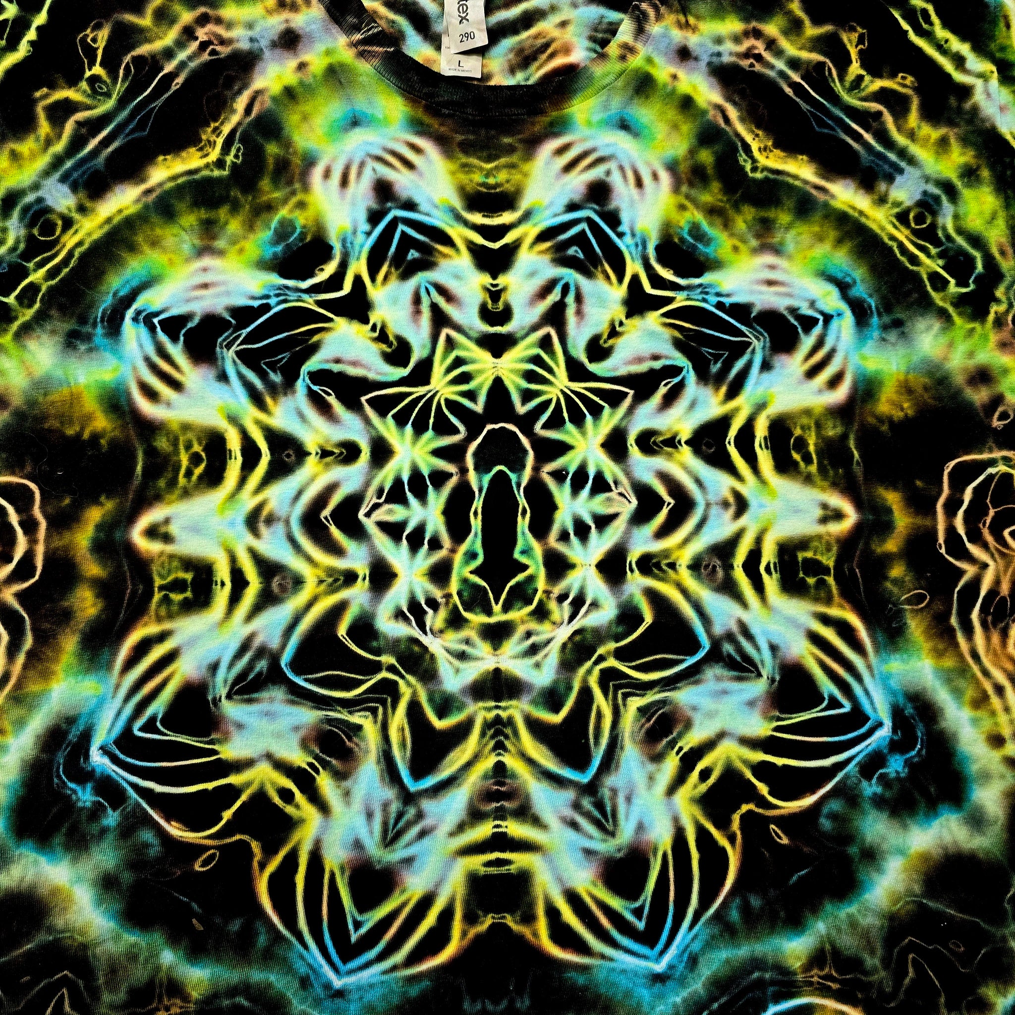 A highly symmetrical, kaleidoscopic abstract pattern with neon yellow, green, and cyan glowing linework over a black background, filling the entire frame.