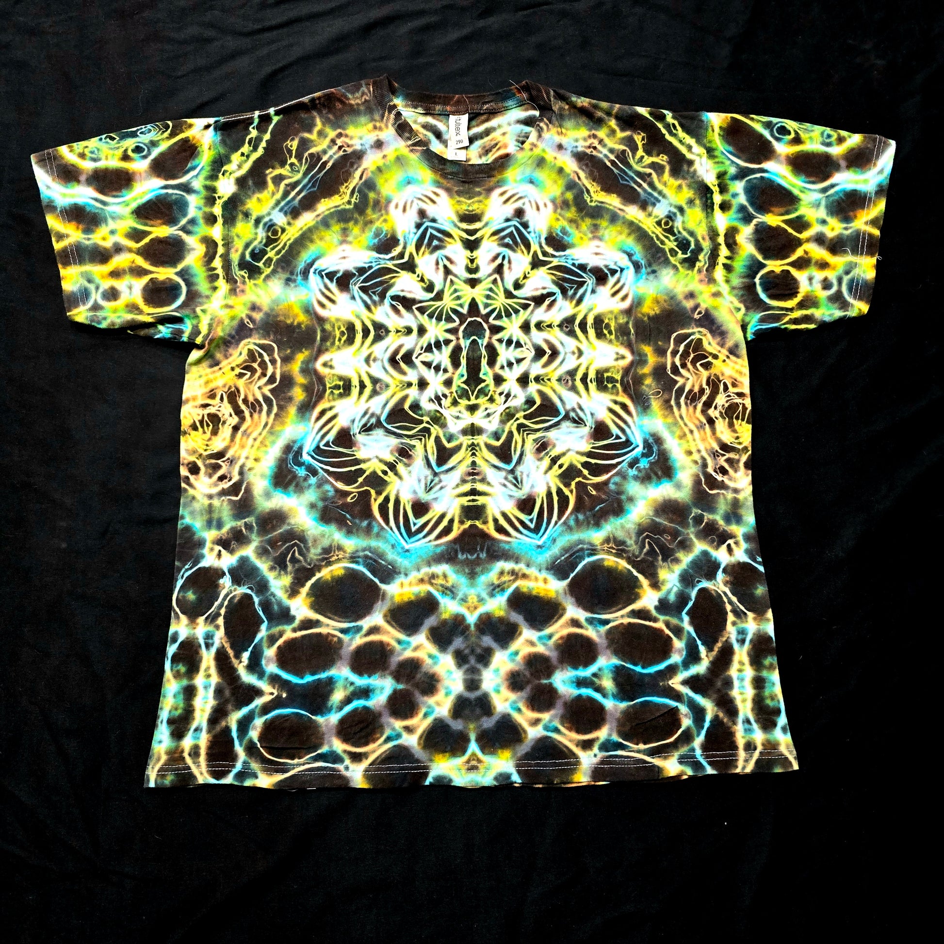 Handmade tie-dye tee with luminous blue, gold, and turquoise mirrored fractal pattern, front view