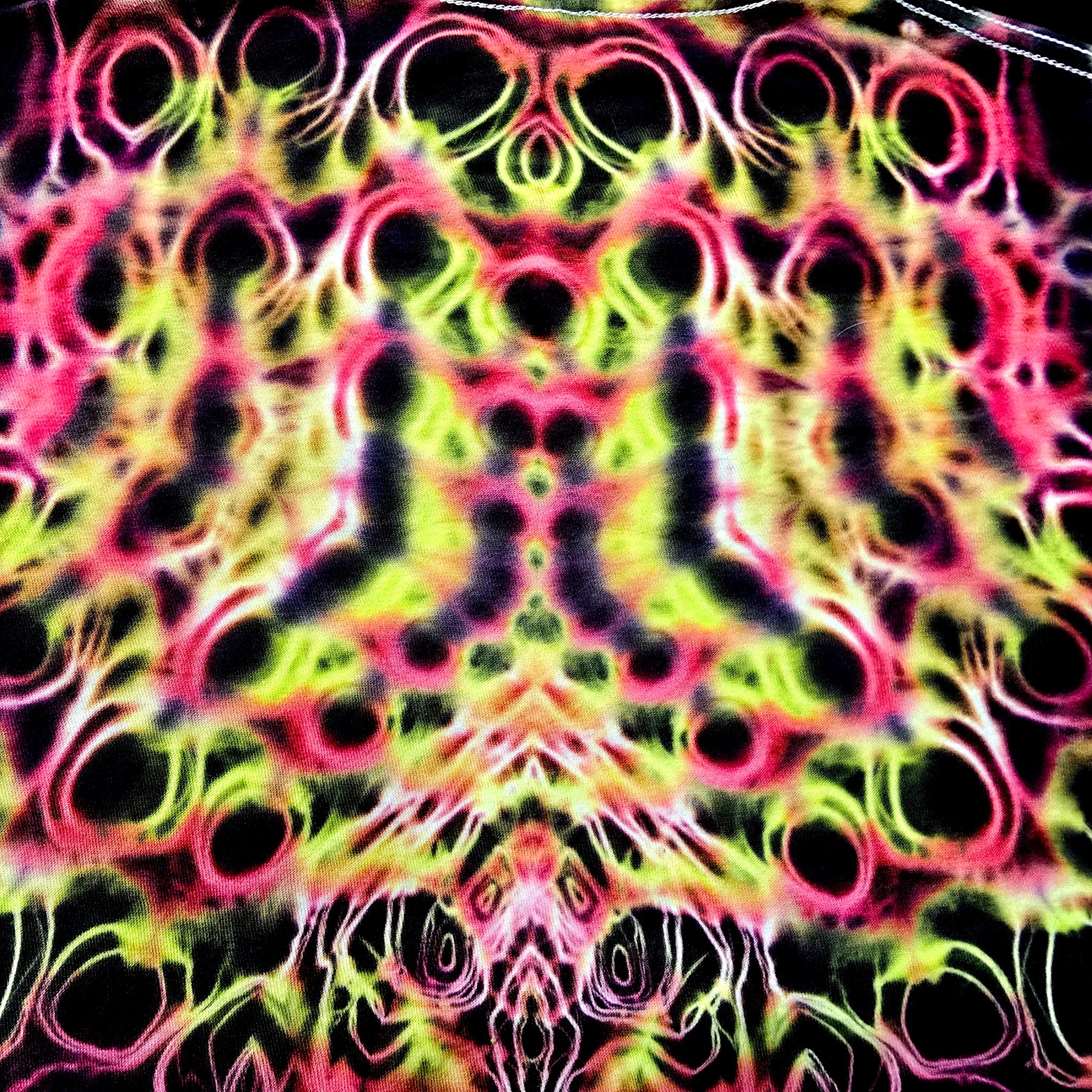 Colorful tie-dye pattern with black circles on a multicolored background