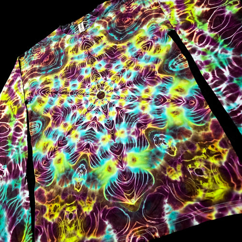 A long-sleeve t-shirt featuring a vibrant, psychedelic tie-dye pattern with a kaleidoscopic mandala design in neon yellow, green, purple, and blue, shown against a black background.