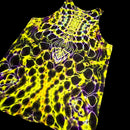 A sleeveless tank top with a vibrant neon yellow and purple cellular or bubble-like pattern, shown against a solid black background.