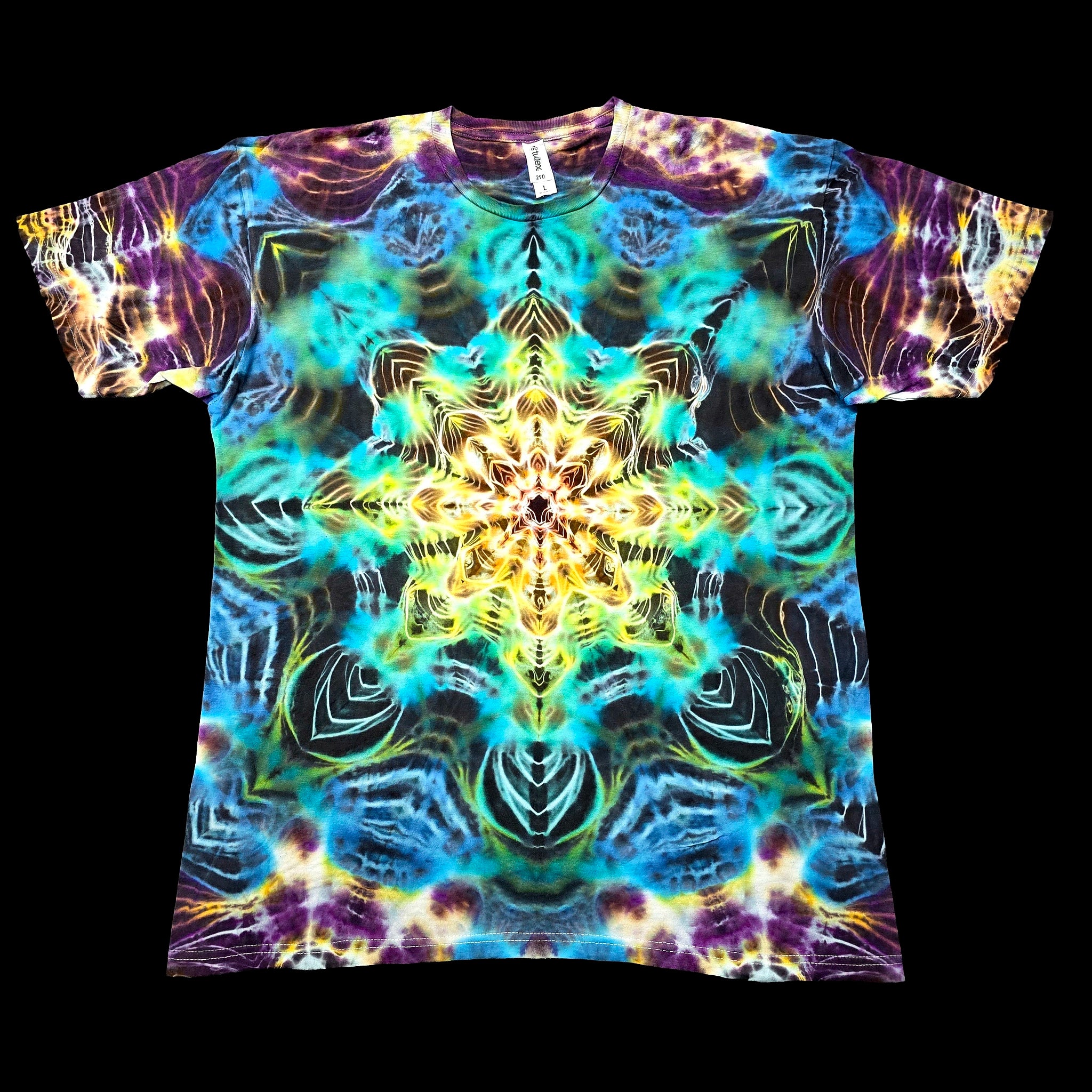 A short-sleeve crewneck t-shirt featuring a vibrant, symmetrical psychedelic mandala tie-dye pattern in shades of blue, yellow, purple, and green, displayed flat against a solid black background.