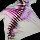 A white short-sleeve tie-dye t-shirt laid flat against a solid black background, featuring a diagonal rainbow tie-dye pattern with purple, pink, yellow, and green hues.