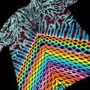A close-up of a tie-dye t-shirt featuring a complex pattern of black, white, purple, and blue on the upper portion, transitioning into a vibrant rainbow geometric wave design on the lower portion, set against a solid black background.