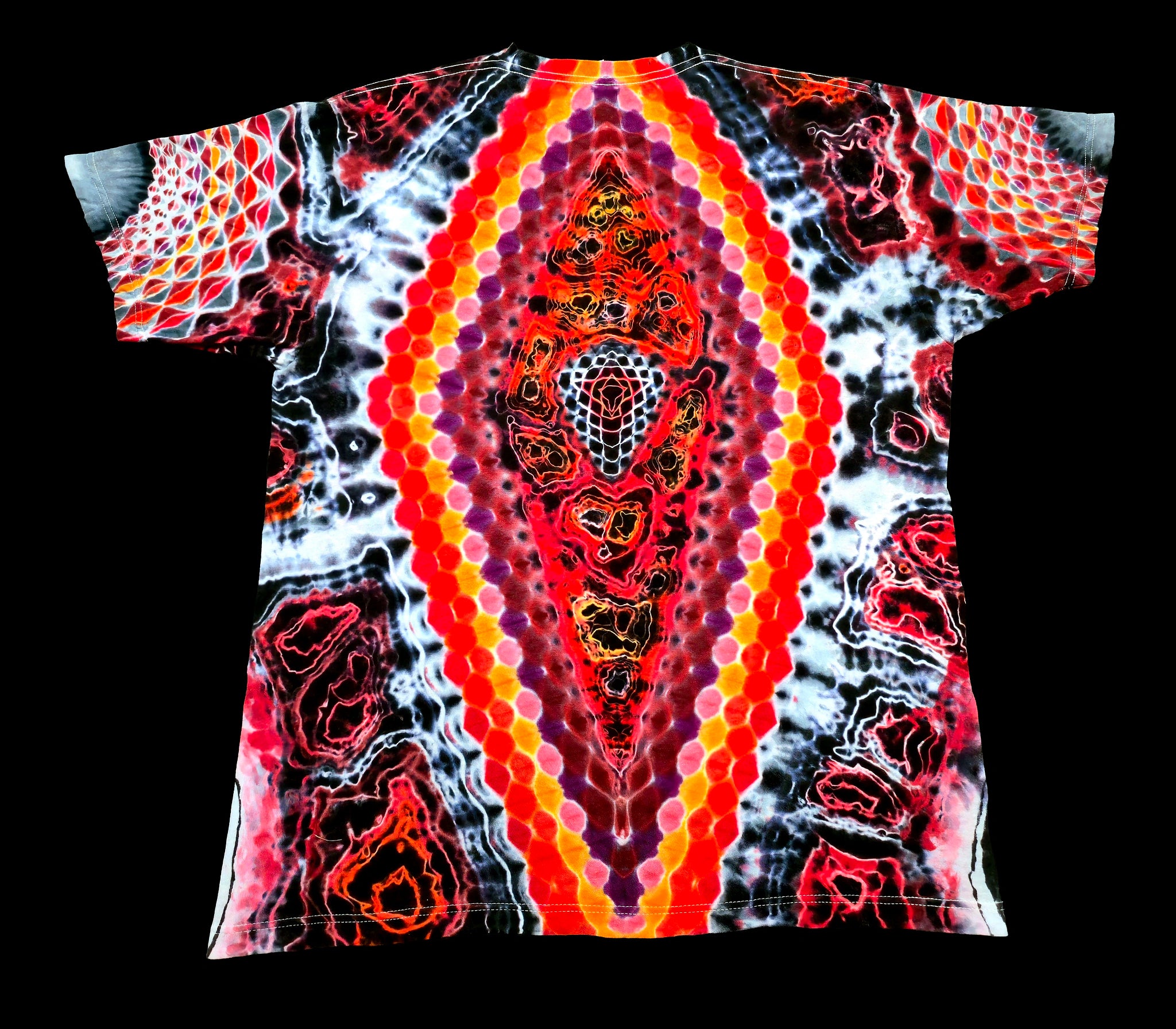 A short-sleeve t-shirt with a vibrant, symmetrical tie-dye pattern featuring concentric hexagonal dots and abstract organic shapes in red, orange, yellow, purple, and black on a white background, shown flat against a solid black backdrop.
