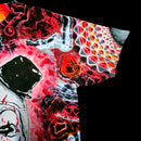 A close-up of a short-sleeve t-shirt featuring a highly vibrant, psychedelic abstract print with red, black, white, and orange patterns, set against a solid black background.