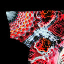 A close-up of a short-sleeve t-shirt featuring a vibrant, multicolor abstract print with red, orange, black, and white organic patterns, set against a solid black background.