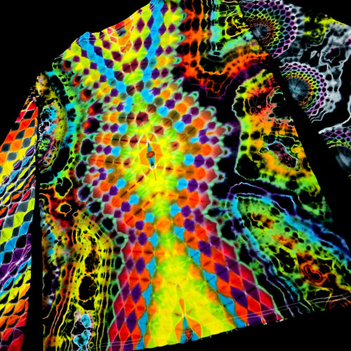 A close-up of a garment featuring a highly vibrant, psychedelic tie-dye pattern with neon rainbow colors including yellow, green, blue, orange, and purple on a black base.