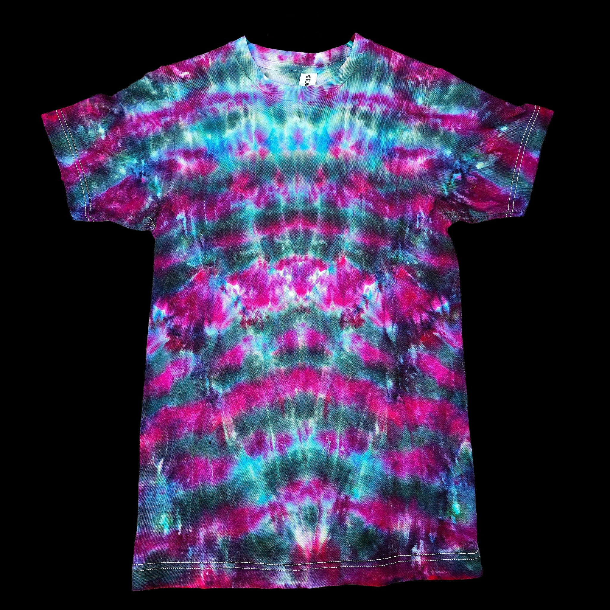 A short-sleeve tie-dye t-shirt. The shirt features a vibrant, symmetrical tie-dye pattern with waves of magenta pink, teal blue, and dark green.
