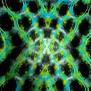 A close-up of a tie-dye fabric or material featuring a symmetrical, scale-like pattern in black, bright green, cyan, and yellow.