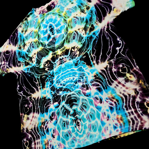 A short-sleeve t-shirt with a vibrant, psychedelic tie-dye pattern featuring swirling waves of turquoise, purple, yellow, and white on a black base, shown against a solid black background.