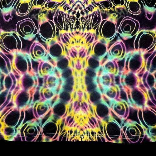 A close-up of a tie-dye fabric with a highly symmetrical, psychedelic pattern featuring neon yellow, pink, green, and purple swirls and circular motifs on a dark base.
