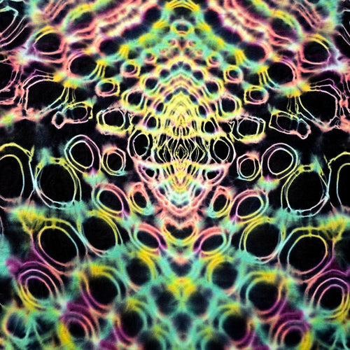 A close-up of a tie-dye fabric featuring a symmetrical, kaleidoscopic pattern of neon pink, yellow, green, and blue rings on a black background.