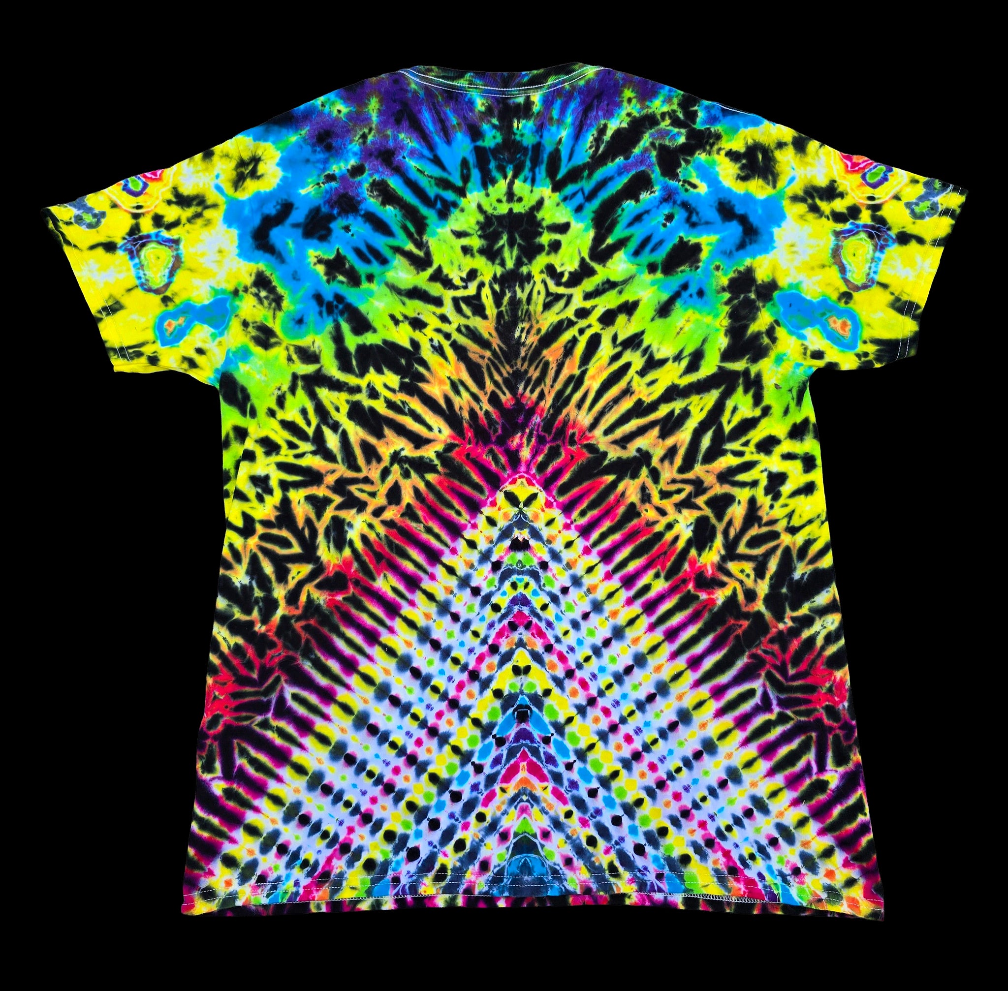 A short-sleeve crewneck t-shirt featuring a vibrant, symmetrical tie-dye pattern with neon yellow, green, blue, pink, and purple radiating from the collar, displayed flat against a solid black background.