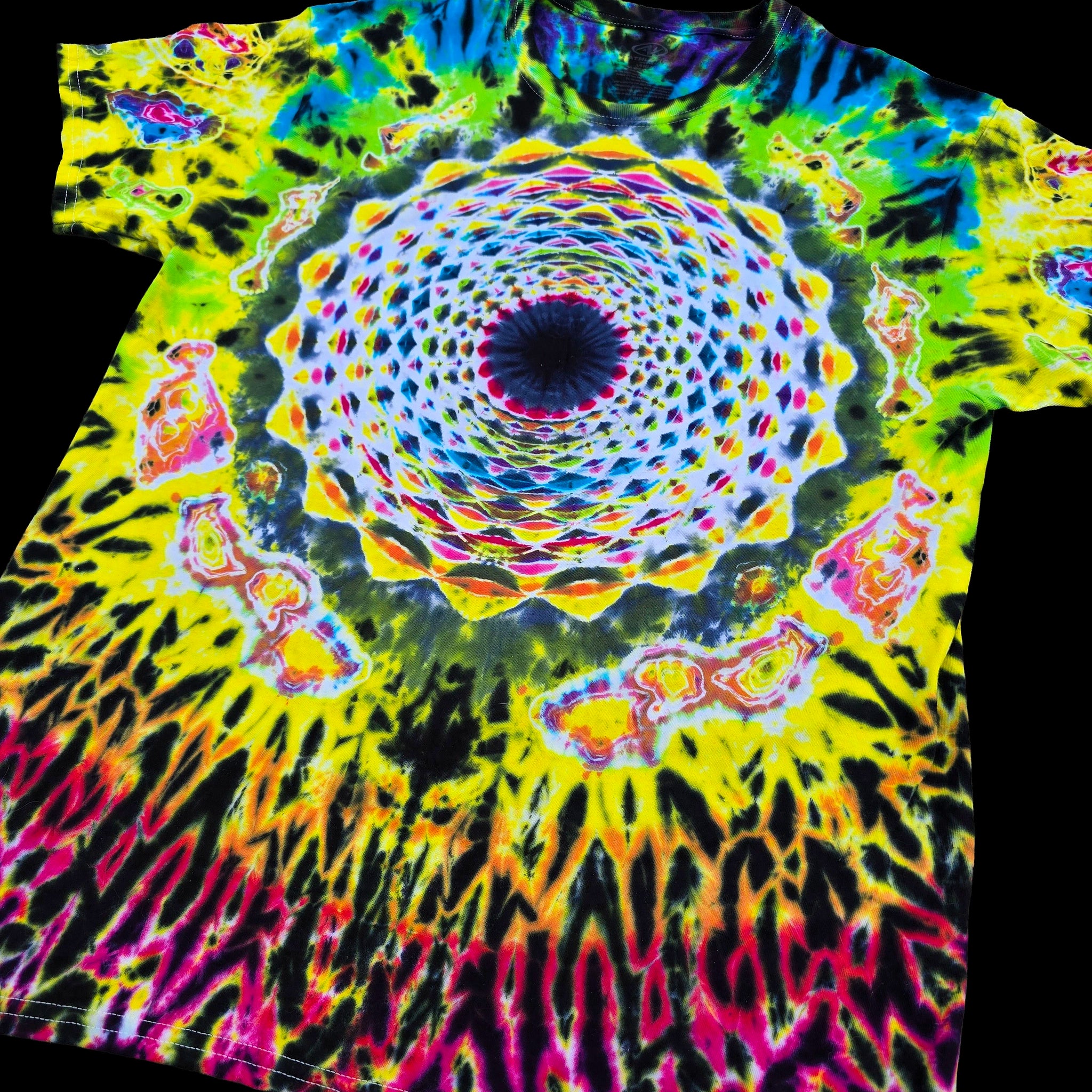A short-sleeve tie-dye T-shirt laid flat against a black background, featuring a vivid psychedelic mandala and tunnel design with neon yellow, green, blue, pink, orange, and black swirls.
