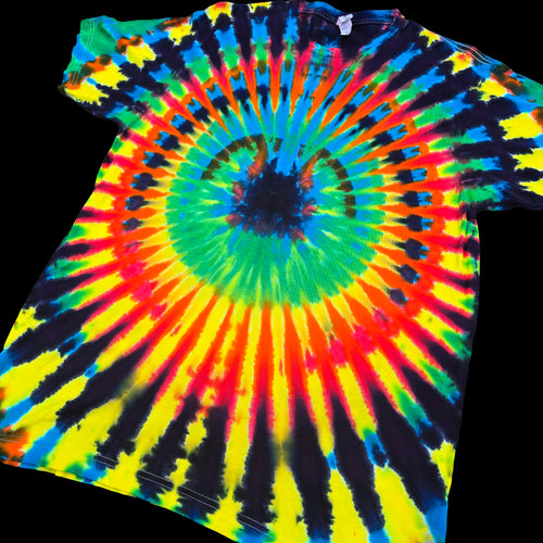 A classic tie-dye t-shirt featuring a vibrant spiral pattern with neon yellow, green, blue, red, and black, laid flat against a solid black background.