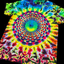 A short-sleeve tie-dye T-shirt laid flat on a black background, featuring a large concentric mandala-style spiral pattern in bright neon colors including yellow, green, blue, red, orange, purple, and black.
