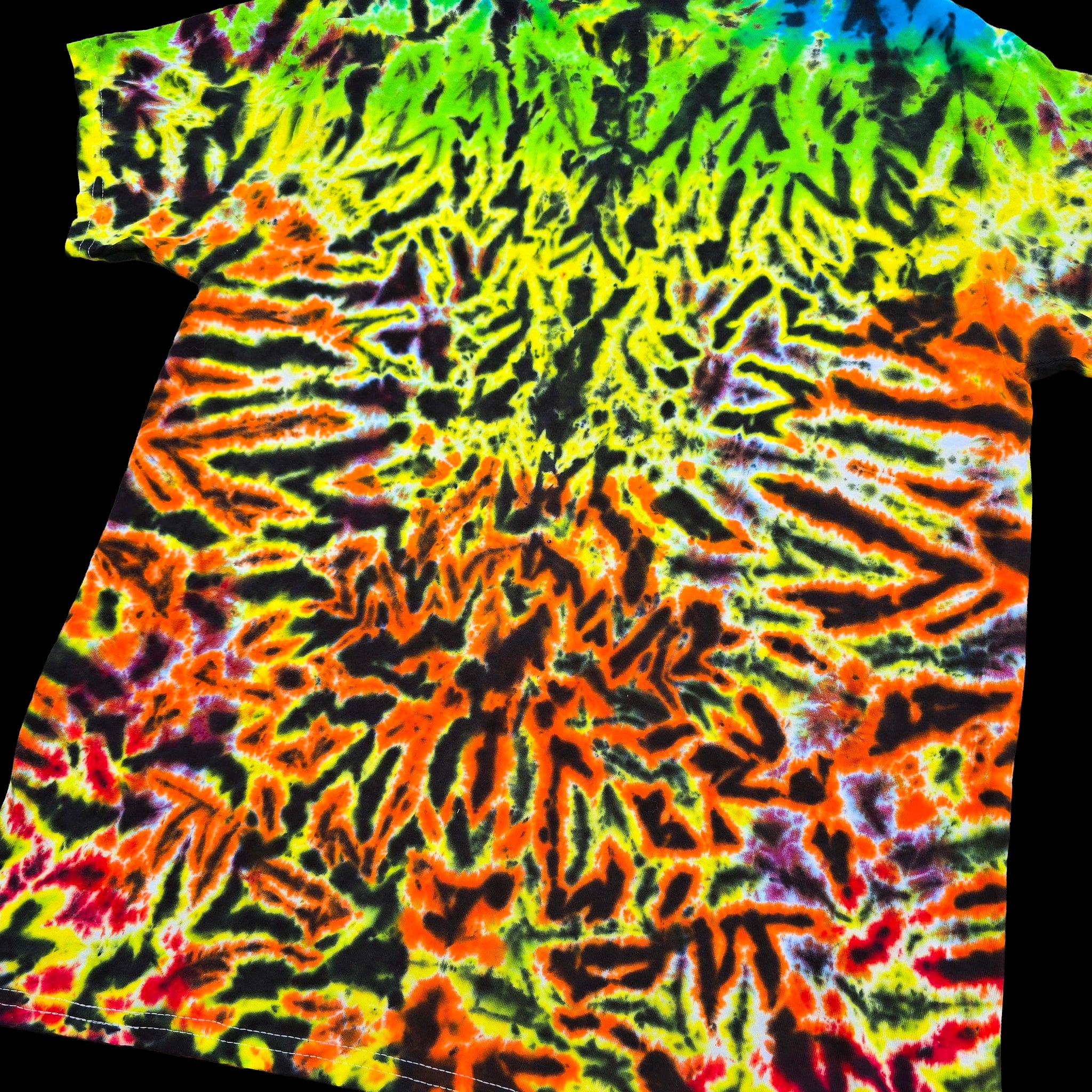 A short-sleeve tie-dye t-shirt with a highly vibrant, symmetrical mandala-like pattern in neon green, yellow, orange, red, and black, shown against a solid black background.
