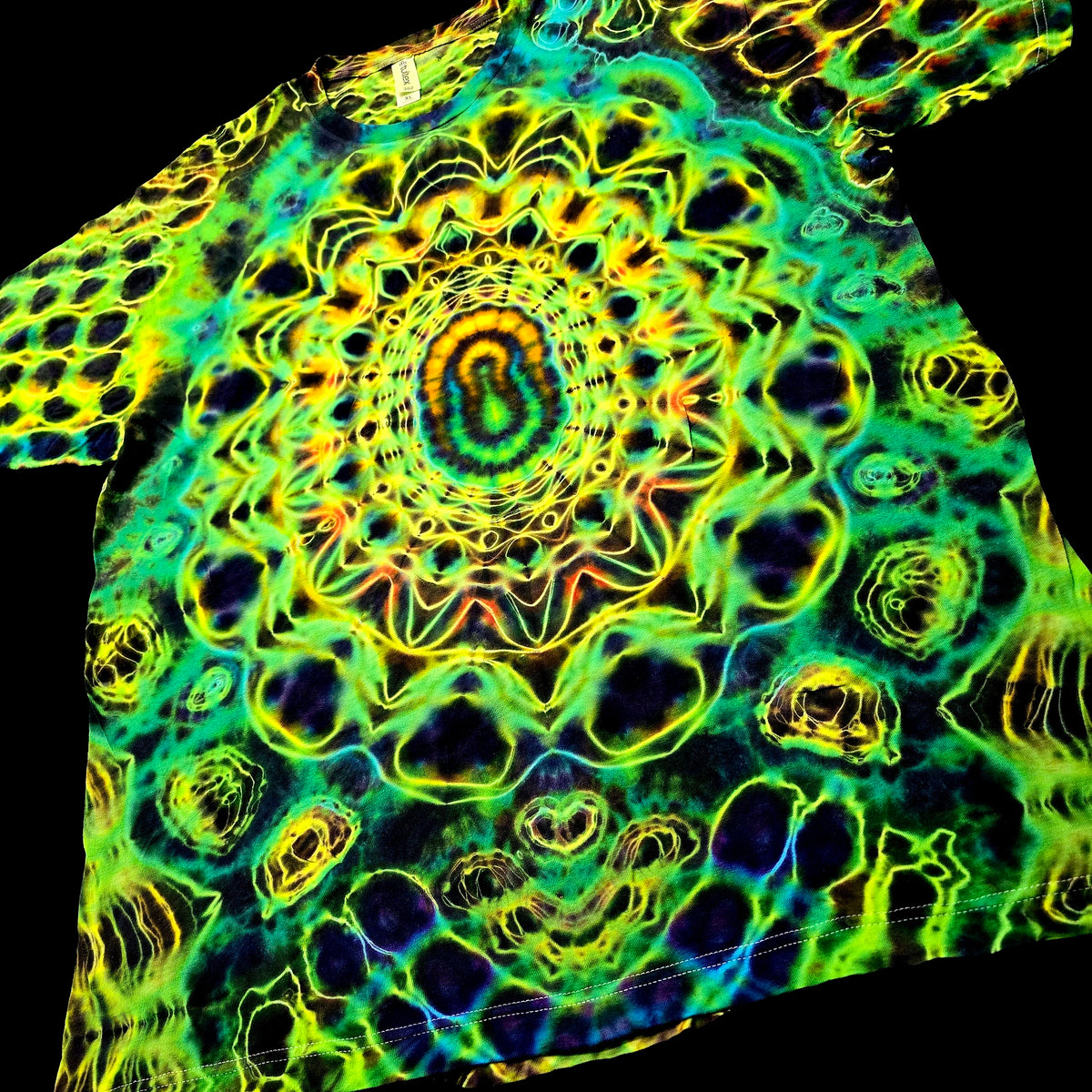 A close-up of a garment featuring a vivid psychedelic mandala pattern in neon green, yellow, blue, and purple on a black background.