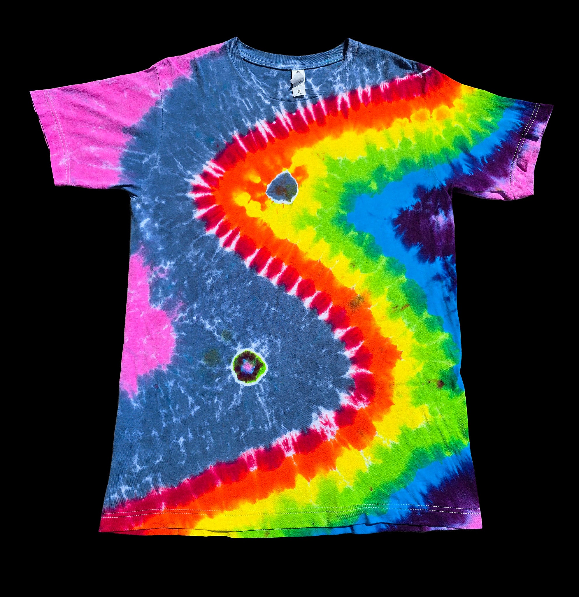 A short-sleeve tie-dye T-shirt. The shirt features a large, stylized wave pattern in a rainbow of colors including pink, blue, yellow, green, orange, and purple, with two small circular holes.