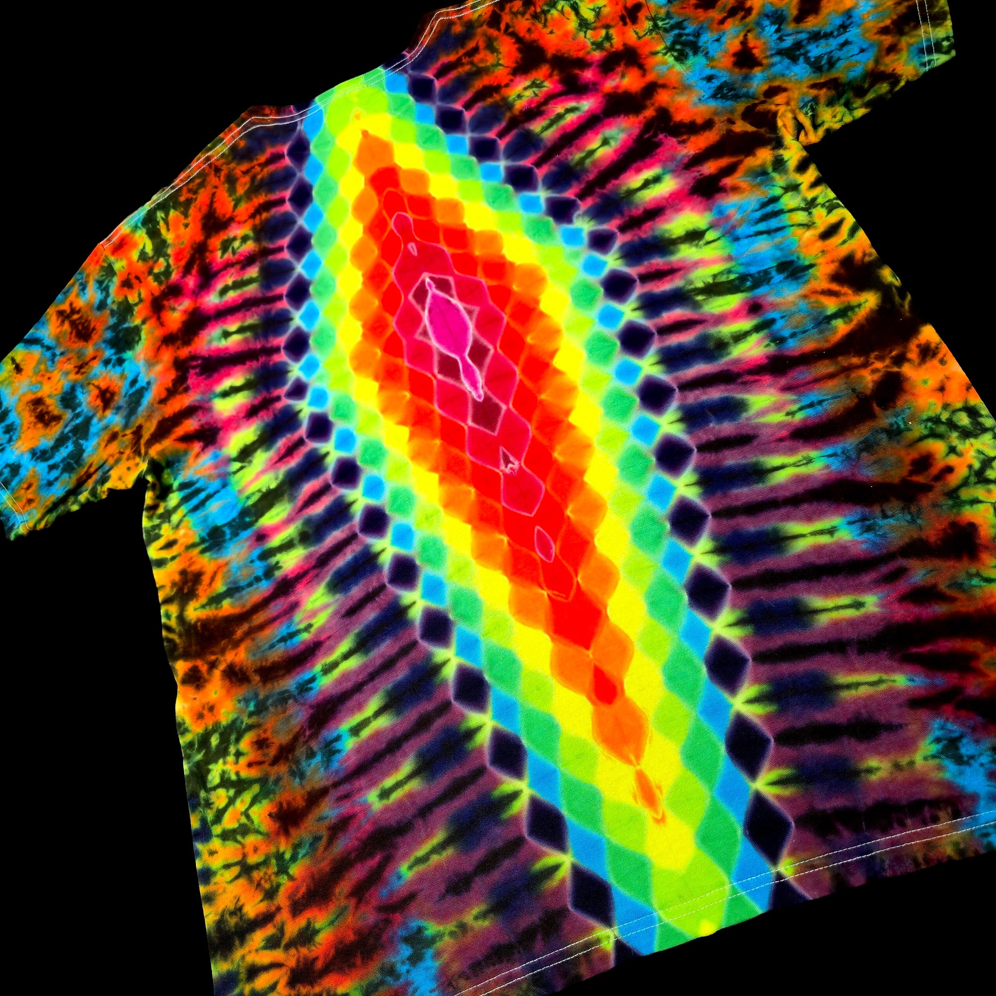 A short-sleeve tie-dye t-shirt featuring a vibrant neon rainbow pattern with a central diamond-shaped gradient of red, orange, yellow, green, and blue, surrounded by darker purple and black tie-dye swirls, shown against a solid black background.
