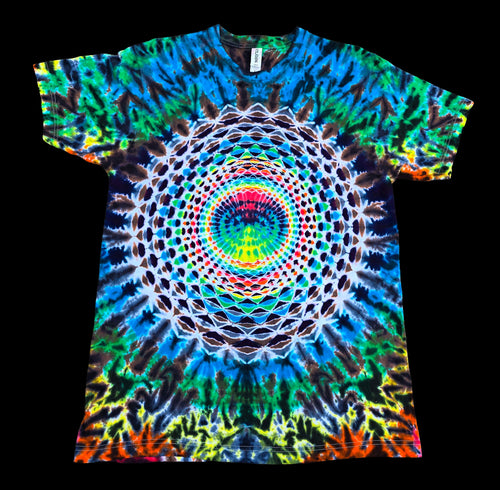 A short-sleeve crewneck t-shirt featuring a vibrant, symmetrical psychedelic mandala print with concentric circles and a rainbow spectrum of colors, shown flat against a solid black background.