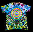 A short-sleeve crewneck tie-dye t-shirt featuring a vibrant psychedelic mandala pattern with concentric circles and radiating stripes in neon yellow, green, blue, pink, purple, and black, displayed flat against a solid black background.