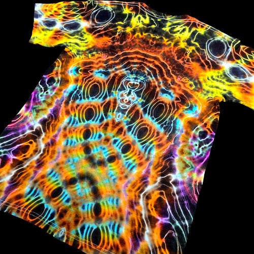 A short-sleeve crewneck t-shirt featuring a vibrant, psychedelic tie-dye pattern with concentric circles and wavy lines in neon orange, yellow, blue, purple, and black, shown against a solid black background.
