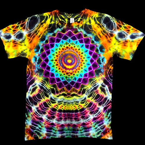 A short-sleeve crewneck t-shirt featuring a vibrant, symmetrical psychedelic mandala print with a rainbow spiral at the center and neon geometric patterns in yellow, orange, purple, blue, and pink on a black background.