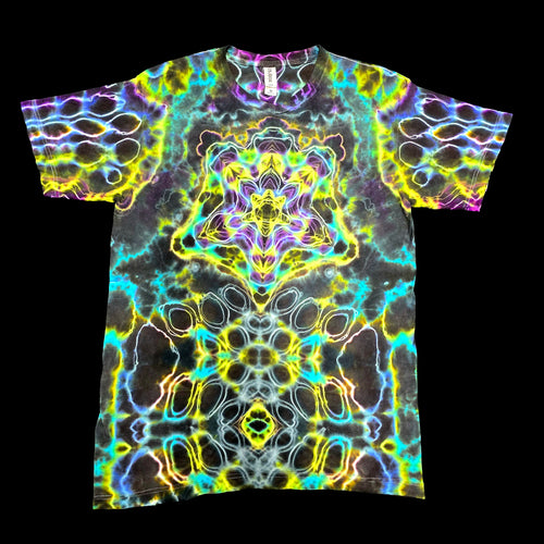 A short-sleeve crewneck t-shirt featuring a vibrant, symmetrical psychedelic kaleidoscope pattern with neon yellow, green, blue, purple, and pink glowing lines over a dark charcoal base.