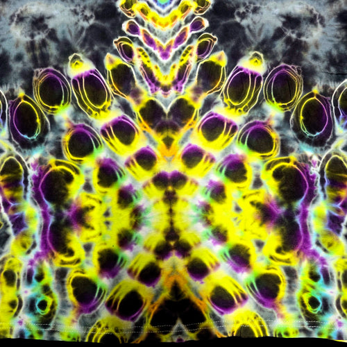 Close-up of a tie-dye fabric with a symmetrical, kaleidoscopic pattern in neon yellow, purple, green, and black.