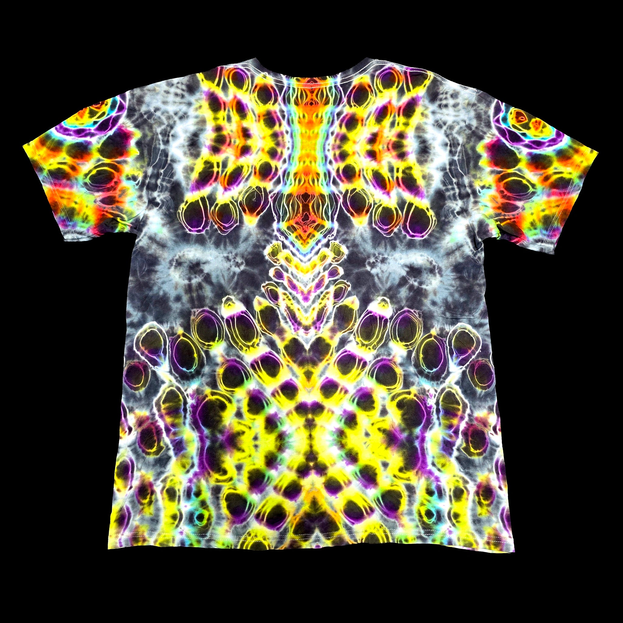 A short-sleeve crewneck t-shirt featuring a vibrant, symmetrical psychedelic pattern with neon yellow, purple, green, and orange tie-dye swirls on a black background.