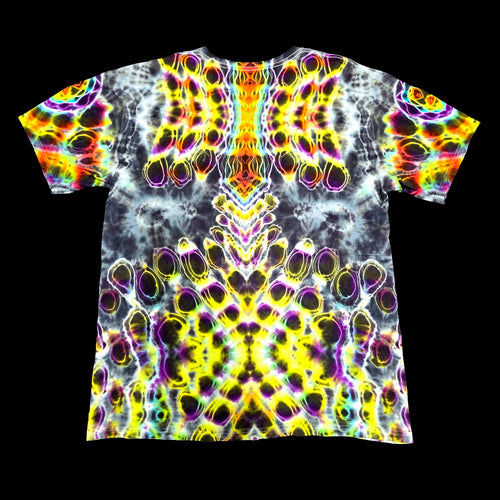 A short-sleeve crewneck t-shirt featuring a vibrant, symmetrical psychedelic pattern with neon yellow, purple, green, and orange tie-dye swirls on a black background.