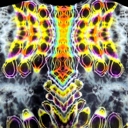 A close-up of a tie-dye garment featuring a highly symmetrical, psychedelic neon pattern with bright yellow, orange, green, blue, and purple swirls over a dark gray and white base.
