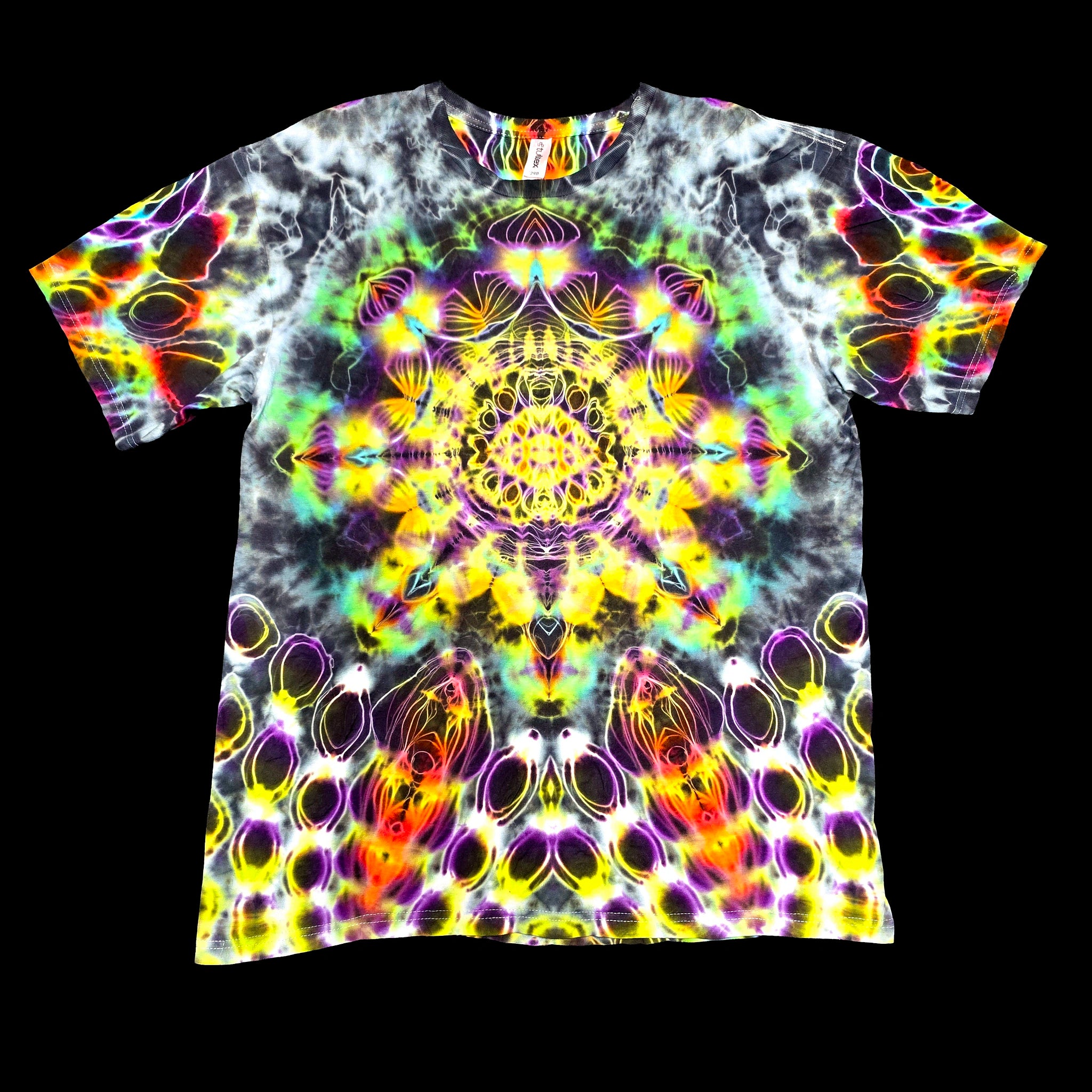 A short-sleeve crewneck t-shirt featuring a vibrant, symmetrical psychedelic mandala print with neon yellow, purple, green, orange, and white patterns over a black background.