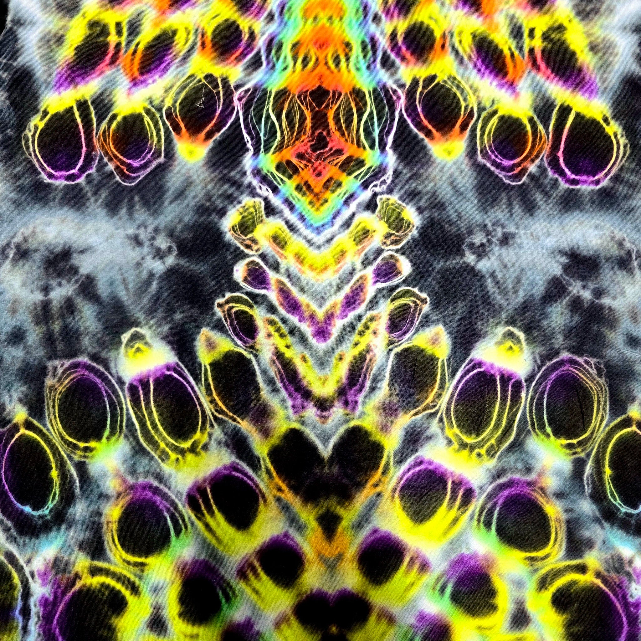 A symmetrical abstract pattern with neon yellow, purple, green, and orange outlines over a dark gray and black marbled background.