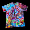 A short-sleeve tie-dye t-shirt with a large spiral pattern in the center, featuring a vibrant mix of blue, pink, purple, yellow, green, and red hues, displayed against a solid black background.