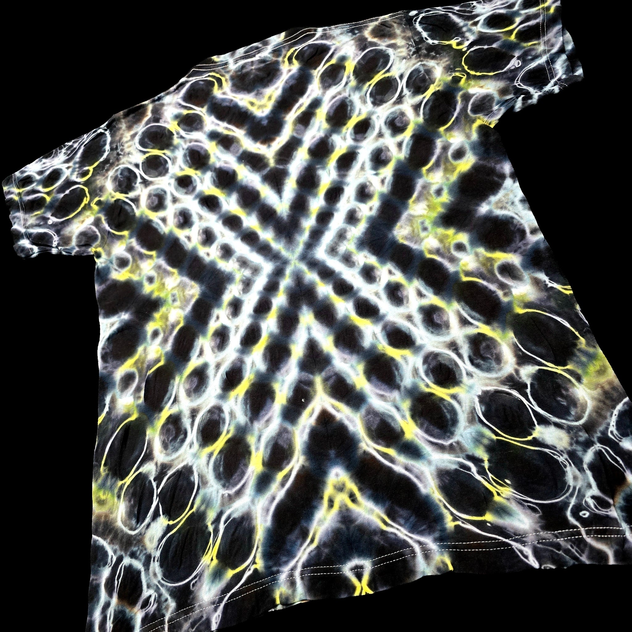 A short-sleeve t-shirt featuring a high-contrast, psychedelic tie-dye pattern of black, white, and neon yellow cells.