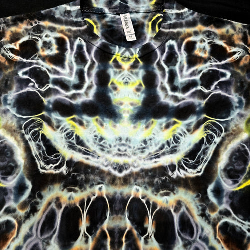 A close-up of a black short-sleeve t-shirt featuring a highly symmetrical, psychedelic tie-dye pattern with white, yellow, and orange organic swirls.