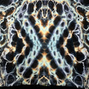 A close-up of a tie-dye fabric with a symmetrical, butterfly-like pattern in black, white, light blue, and orange-brown.