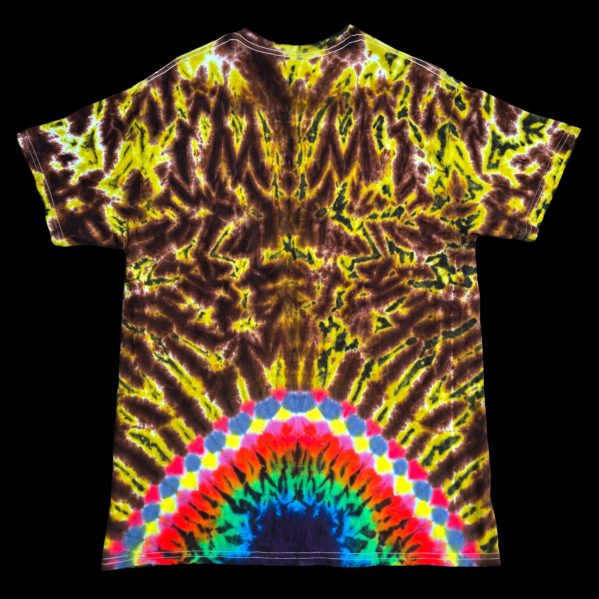A short-sleeve tie-dye t-shirt laid flat against a solid black background. The shirt features a complex, symmetrical psychedelic pattern in yellow, brown, and black, with a vibrant rainbow arch pattern at the bottom hem.