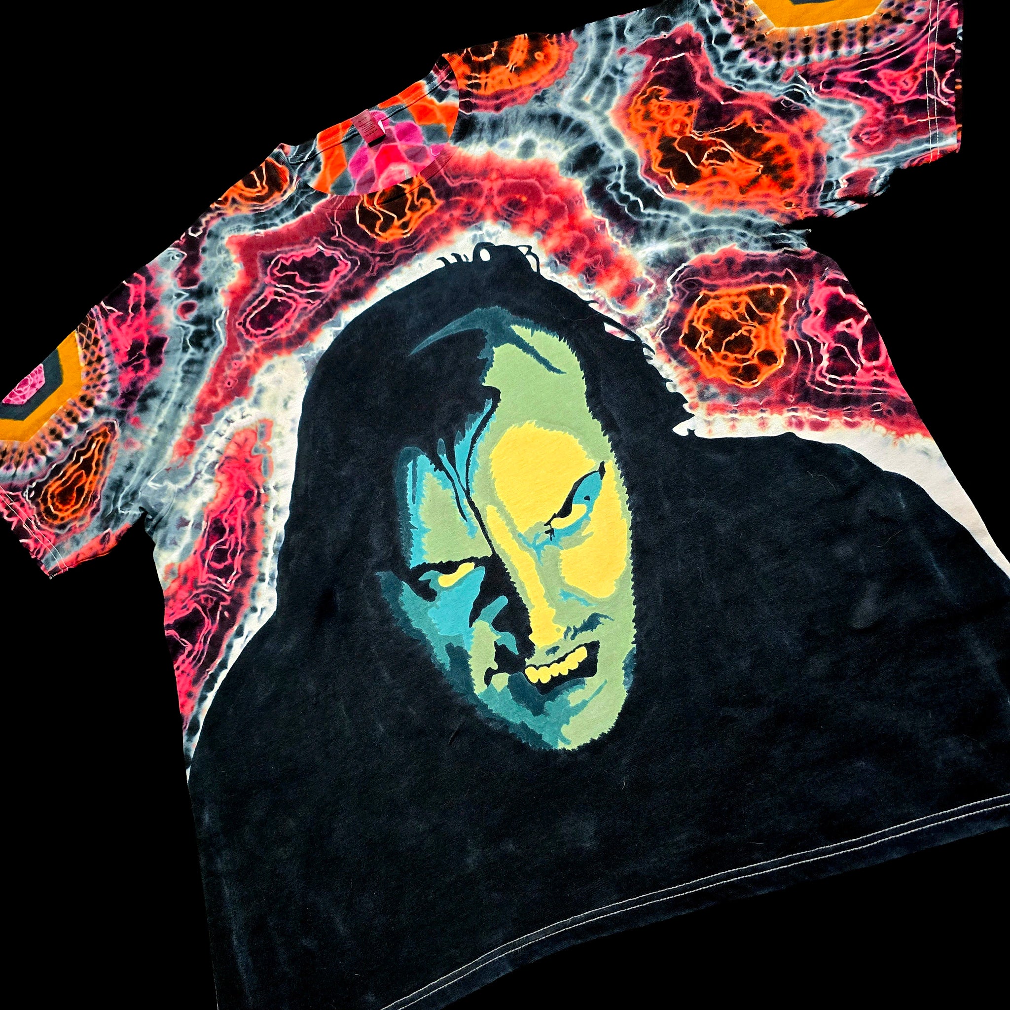 Front angled perspective view of tie dye shirt showing Jack Nicholson face art and red agate sleeve details