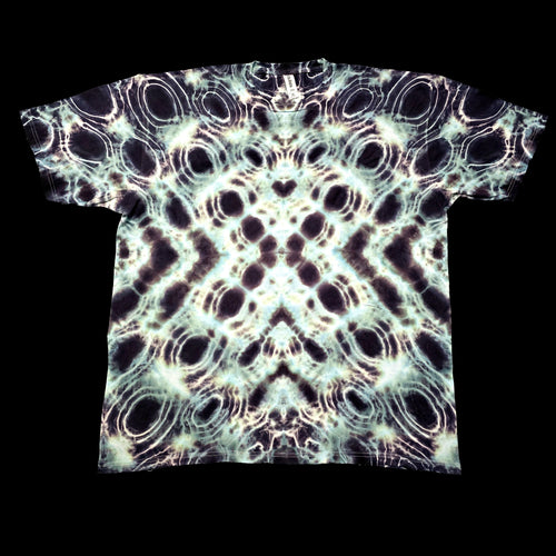 A short-sleeve crewneck t-shirt featuring a symmetrical, kaleidoscopic abstract pattern of black, white, and pale green circles, photographed flat against a solid black background.