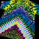 A short-sleeve tie-dye T-shirt laid flat on a black background, featuring a rainbow spiral pattern with a white lower section decorated with multicolored polka dots.